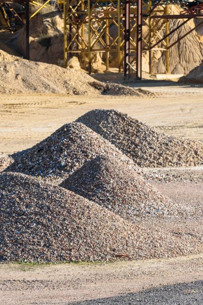 Pile of gravel and sand piled up in a quarry for sale and use in construction.